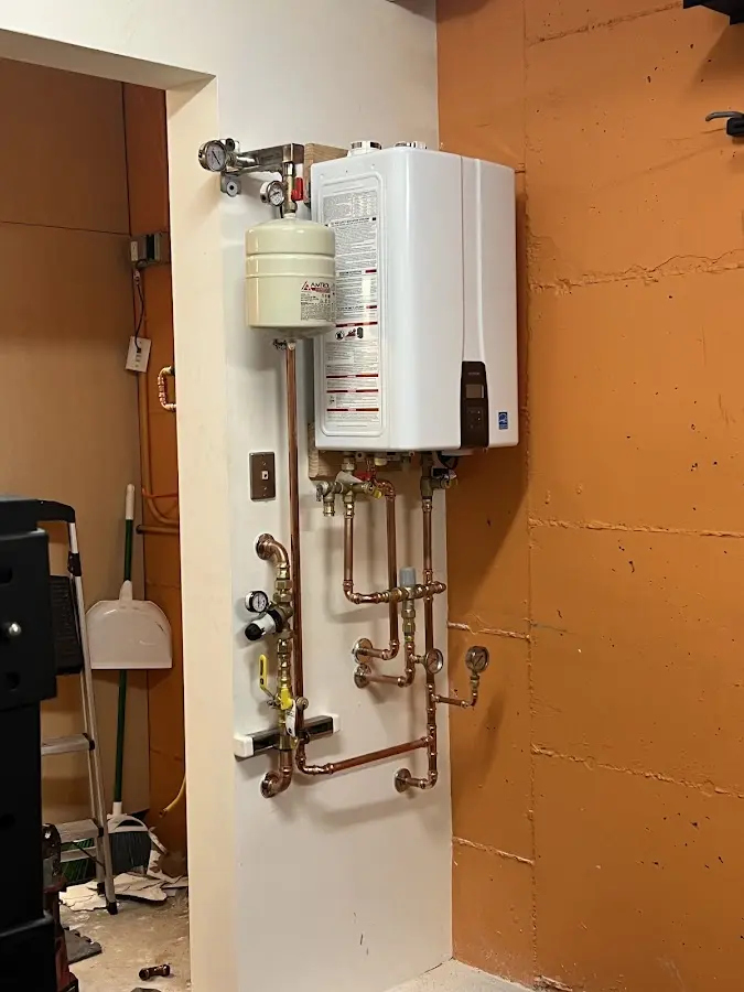 Plumbing technician inspecting water heater connections in Senatobia